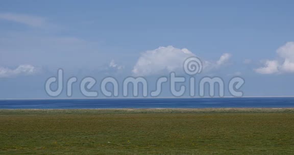 遥远的4k大草原白色蓬松的云团翻滚在蓝色的湖面上视频的预览图
