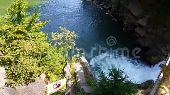 水流在石头间流动清澈的水很快就会下山在黑暗潮湿的石头周围流动瀑布的特写镜头视频的预览图