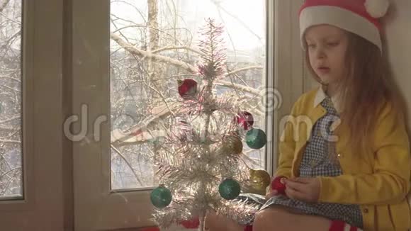 窗台上装饰圣诞树的小女孩视频的预览图