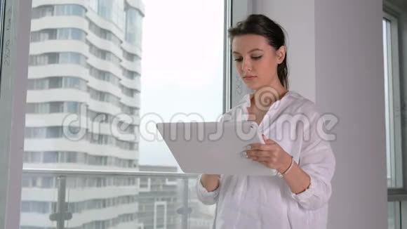 年轻的女商人在办公室里用平板电脑视频的预览图