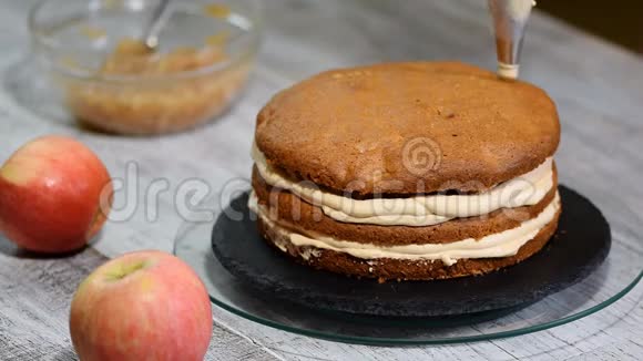 在厨房做焦糖苹果蛋糕厨师用带奶油的糕点包装饰视频的预览图