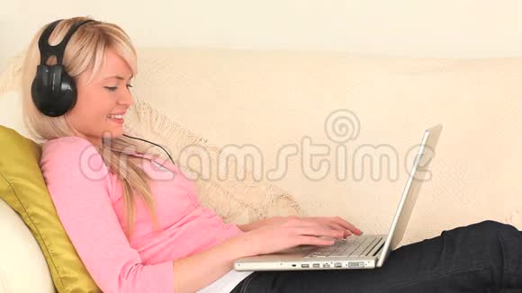 可爱的金发女人在她的笔记本电脑上工作视频的预览图