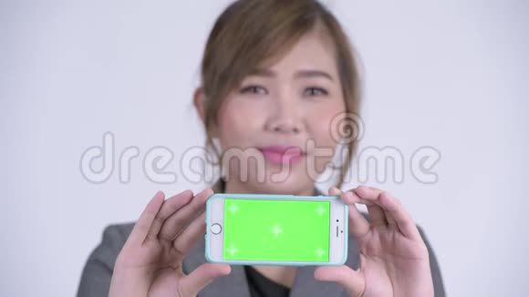 年轻快乐的亚洲女商人带着电话视频的预览图