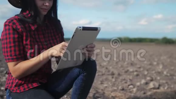 智慧生态是一种收获农业的耕作理念女农民用数字平板电脑研究地球上的泥土视频的预览图
