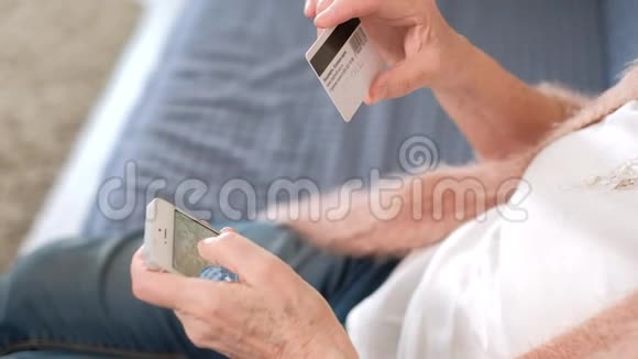 一位老妇人用信用卡和电话进行银行转账视频的预览图