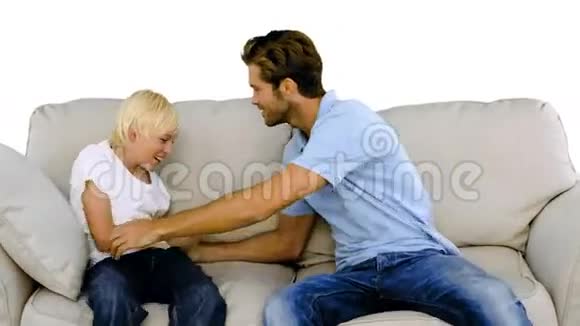 父亲在白色背景的沙发上挠着儿子视频的预览图