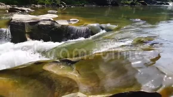 水流在石头间流动清澈的水很快就会下山在黑暗潮湿的石头周围流动瀑布的特写镜头视频的预览图