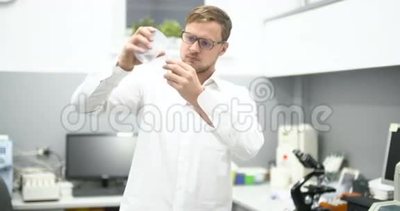 实验室科学家检查玻璃烧杯中的液体视频的预览图