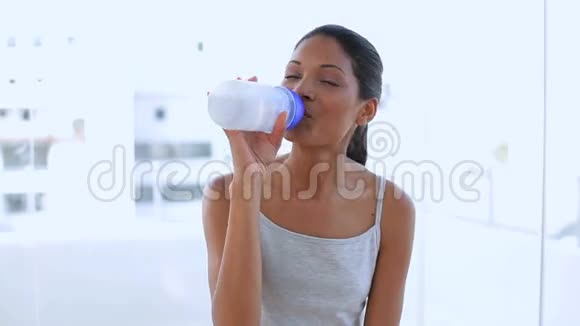 美丽的女人在烧瓶里喝水视频的预览图