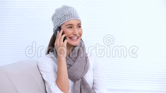 戴着帽子戴着围巾的年轻女子微笑着叫人视频的预览图