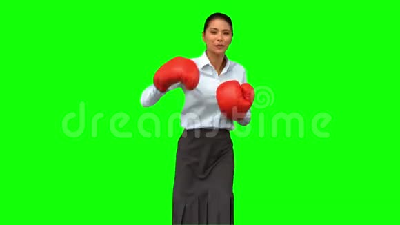戴着拳击手套的女商人打绿屏视频的预览图