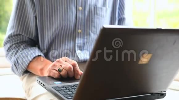 专注的成熟男人用电脑坐在窗边视频的预览图