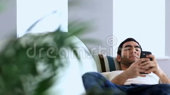 一个人用智能手机躺在沙发上视频的预览图