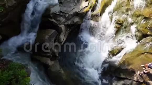 水流在石头间流动清澈的水很快就会下山在黑暗潮湿的石头周围流动瀑布的特写镜头视频的预览图
