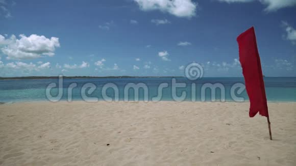 热带岛屿白色沙滩上的红旗视频的预览图