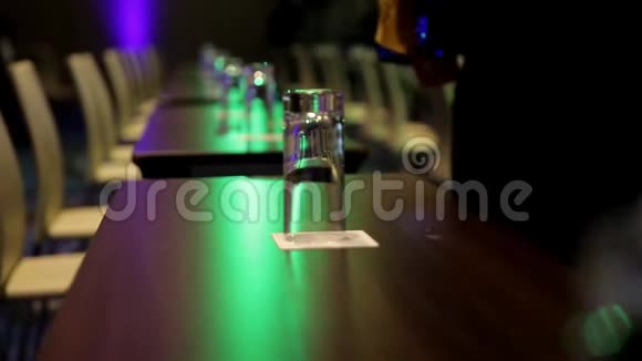 桌子上有水和白色床单的瓶子会议厅里有红椅子视频的预览图