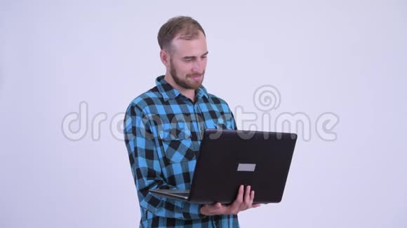 喜欢留胡子的时髦男人在用笔记本电脑思考视频的预览图