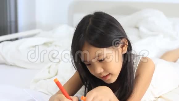 小亚洲女孩微笑着躺在床上视频的预览图