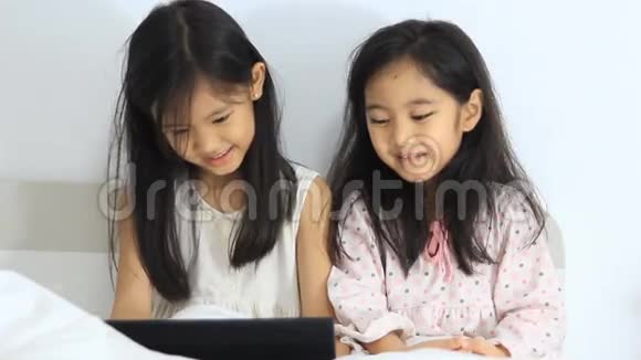 小亚洲女孩用平板电脑笑视频的预览图