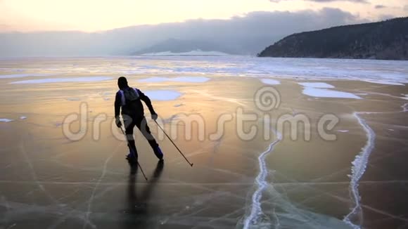 在美丽的日落中人们正在冰封的贝加尔湖上滑冰视频的预览图