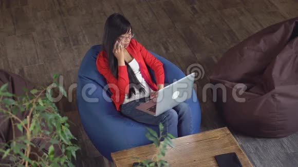 女孩在室内使用智能手机和笔记本电脑视频的预览图
