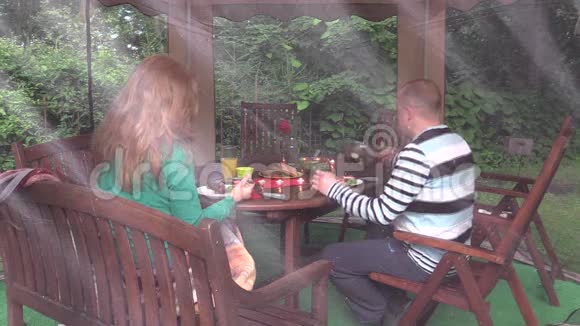 女人和男人坐在餐桌旁点着蜡烛吃食物视频的预览图