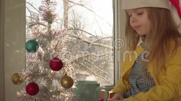 窗台上装饰圣诞树的小女孩视频的预览图