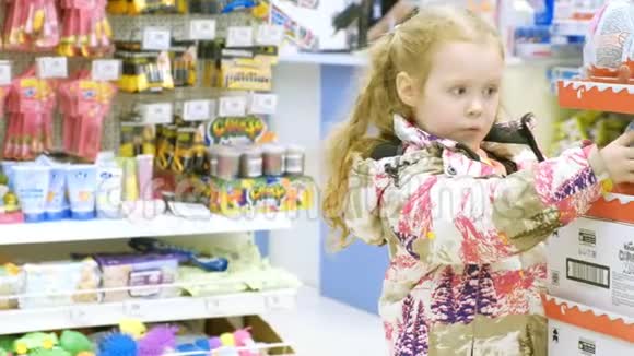 一个漂亮的女孩走在超市边挑选玩具视频的预览图