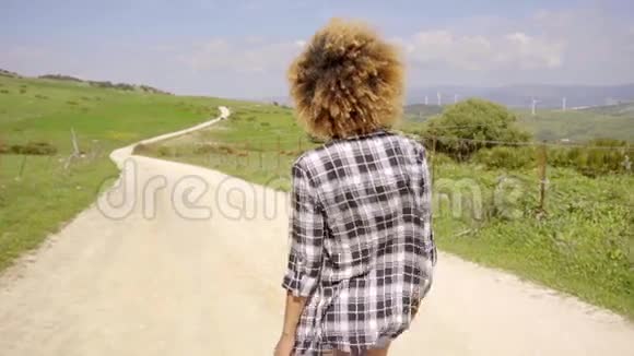 走在乡间路上的女人视频的预览图