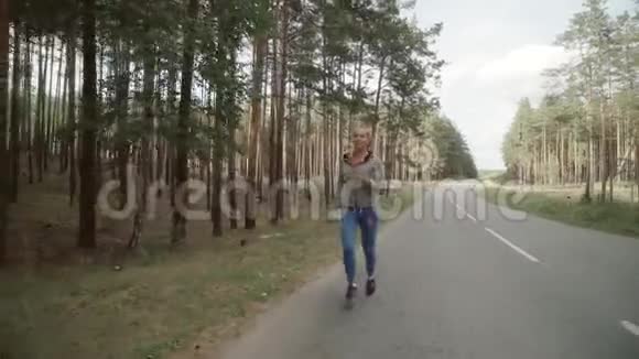 那个女孩在路上的一片松树林里跑步视频的预览图