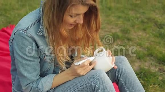 特写女性的手用白色杯子上的一根管子上的油漆画一个图案女孩在坐在上面画装饰品视频的预览图