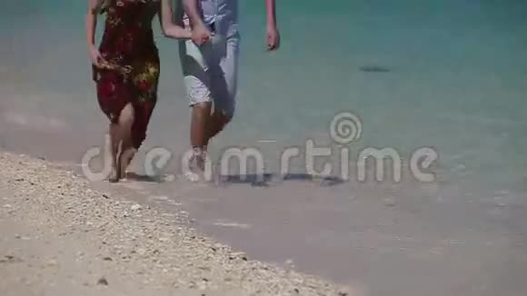 在热带海滩上奔跑的快乐夫妇视频的预览图