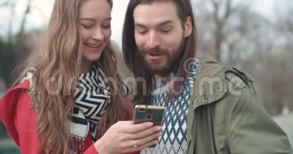 年轻漂亮的夫妇用在线移动应用程序在社交媒体上分享记忆和图片视频的预览图