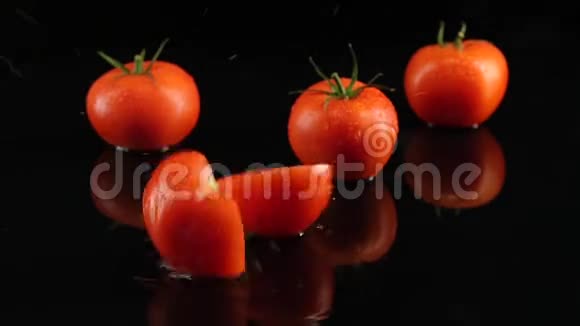番茄正落在桌子上黑色的背景上视频的预览图