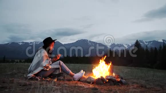 那个穿着暖和毛衣的女孩晚上坐在炉火旁视频的预览图