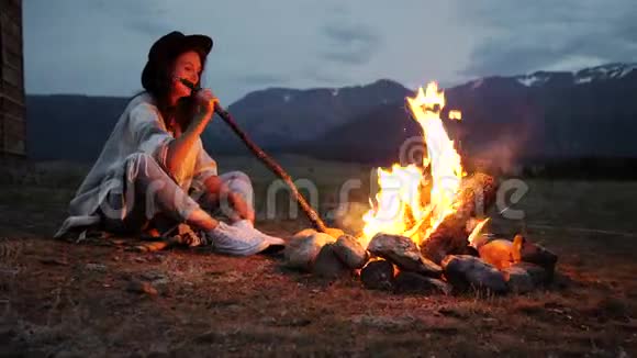 那个穿着暖和毛衣的女孩晚上坐在炉火旁视频的预览图