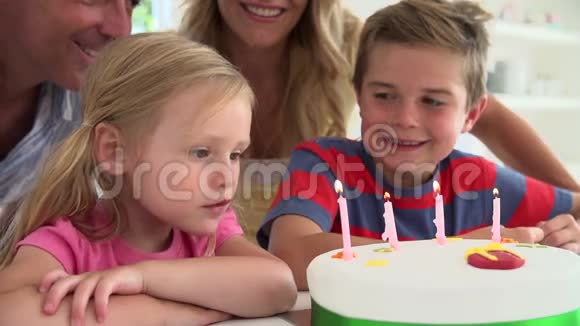 女孩在蛋糕上吹蜡烛的慢动作序列视频的预览图