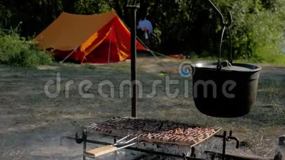 Bowler营地在火堆上做饭露营现场一个装满食物的锅悬在篝火上与Bowler一起视频的预览图
