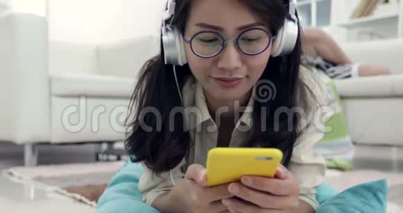年轻的亚洲女人和年轻的男孩一起放松和听音乐视频的预览图