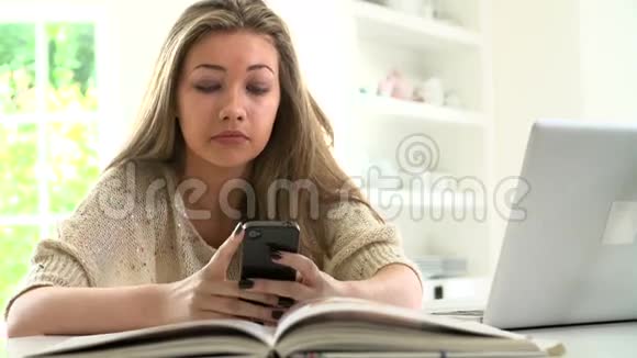少女在笔记本电脑上学习时发送短信视频的预览图