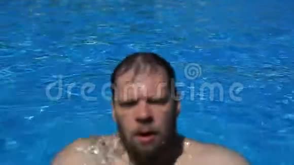 白种人留着胡须的人在晴朗的夏天阳光明媚的一天漂浮在蓝色的游泳池里旅游健康视频的预览图