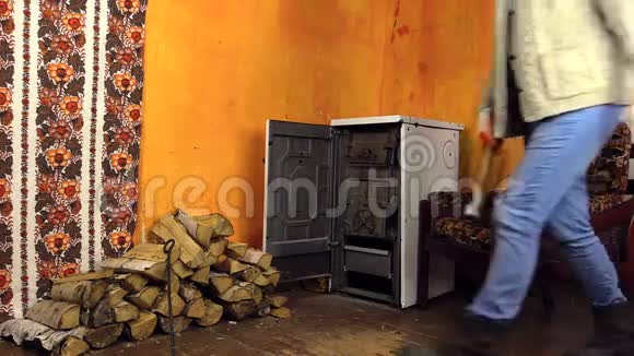女孩打开烤箱门在乡村房间里坐在火炉旁的椅子上视频的预览图