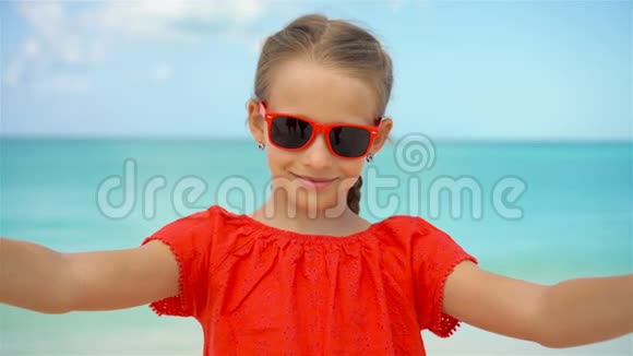 暑假期间快乐的小女孩在异国海岛的热带海滩自拍视频的预览图