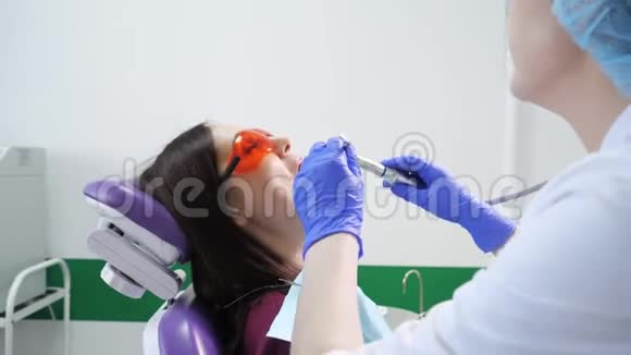 年轻女子在牙医的牙科椅上接受预防性检查牙齿护理概念视频的预览图