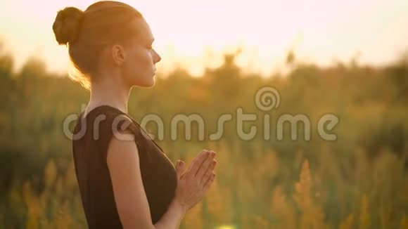 美丽的年轻健康女子在日落时做瑜伽运动视频的预览图