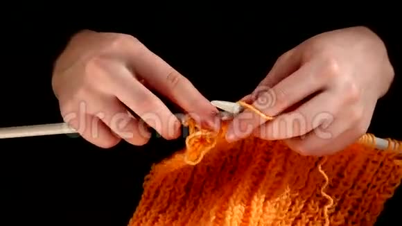 女人坐着编织橙色的围巾大的针织物视频的预览图