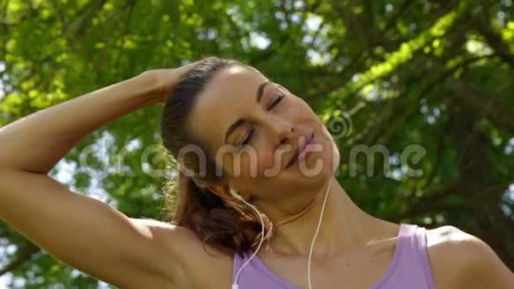 跑步者伸长脖子在公园里听音乐视频的预览图