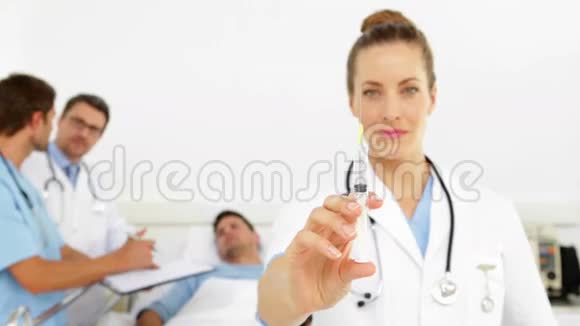 医生在病床上与病人交谈护士准备针头视频的预览图