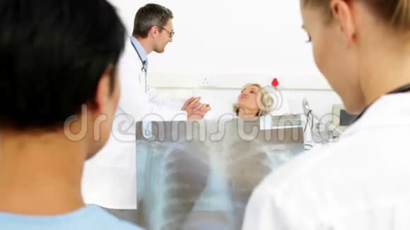 在病床上病人面前研究x射线的医生视频的预览图