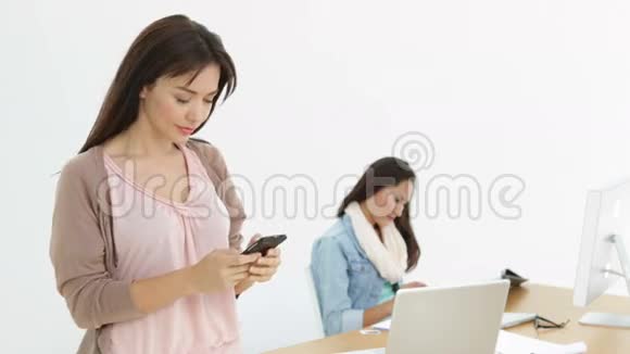 有创意的女商人在她身后和同事发短信视频的预览图